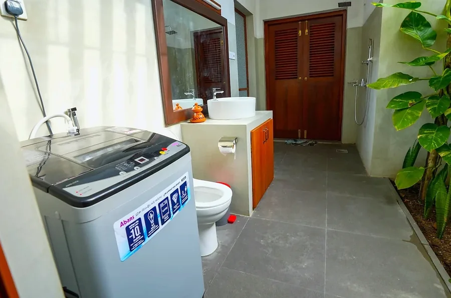 Salle de bains et espace buanderie avec lave-linge — Syndeo Garden, Hikkaduwa