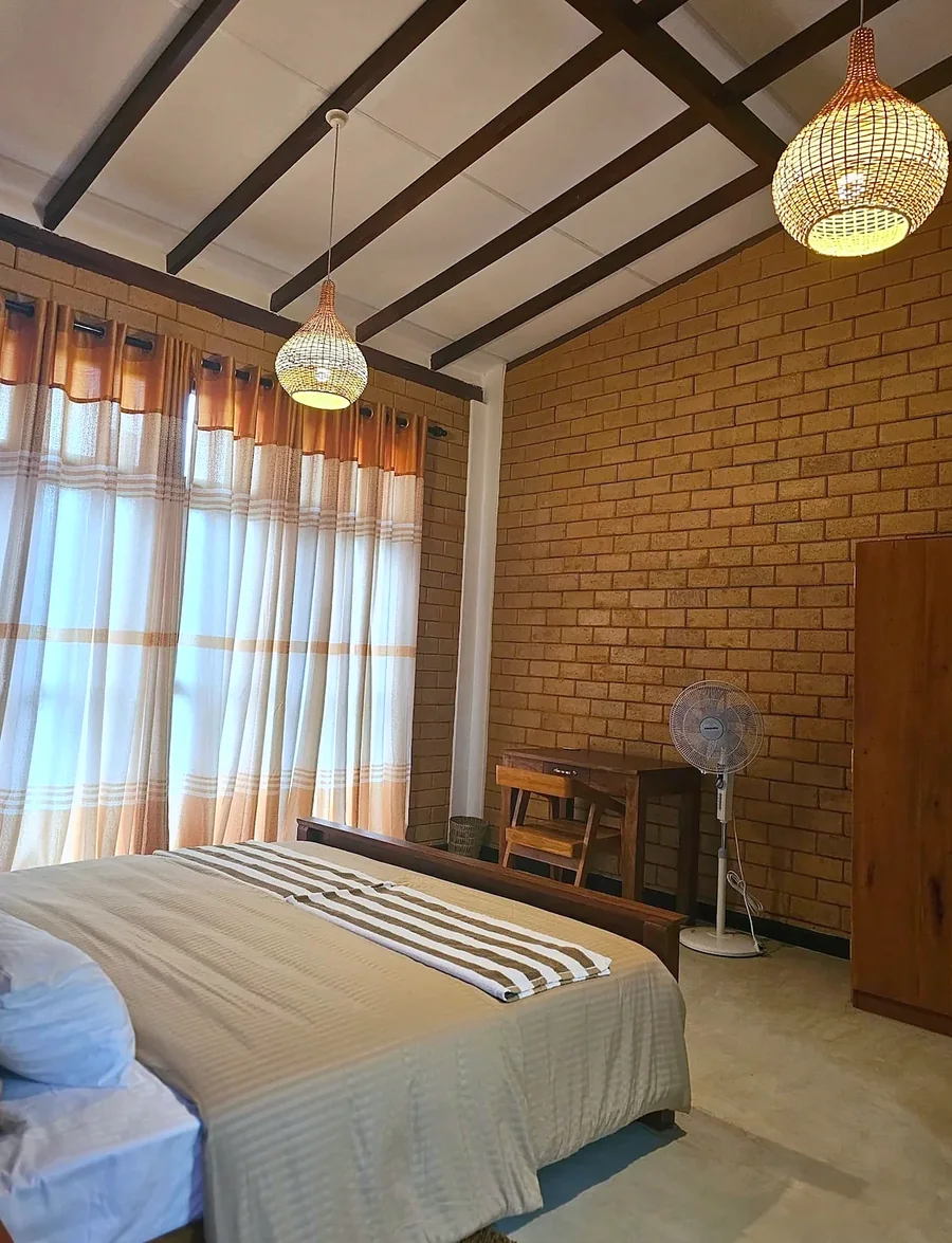 Chambre avec linge rayé et murs de briques — Syndeo Garden, Hikkaduwa