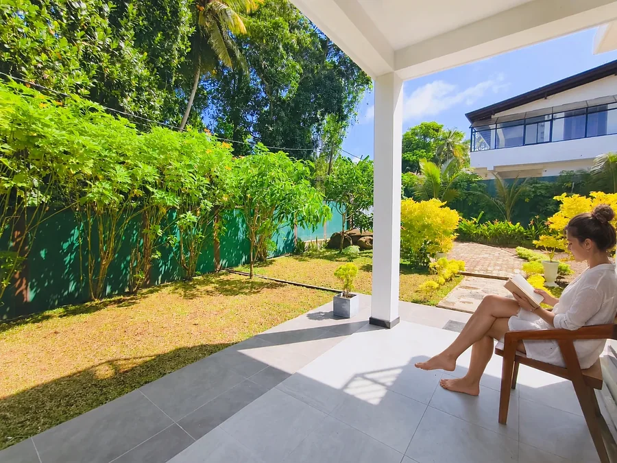 Une voyageuse lit sur la terrasse ombragée du jardin de Syndeo Garden à Hikkaduwa — Syndeo Garden, Hikkaduwa