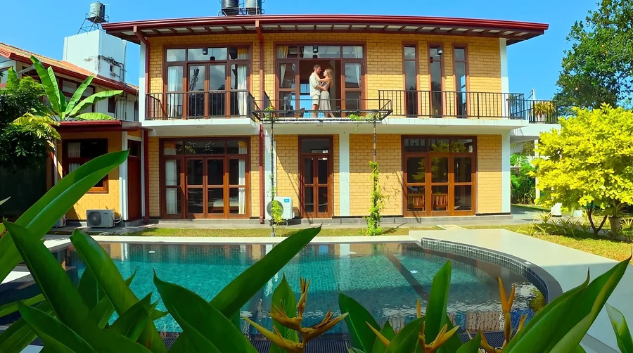La villa et sa piscine privée, avec un couple sur le balcon à l’étage — Syndeo Garden, Hikkaduwa